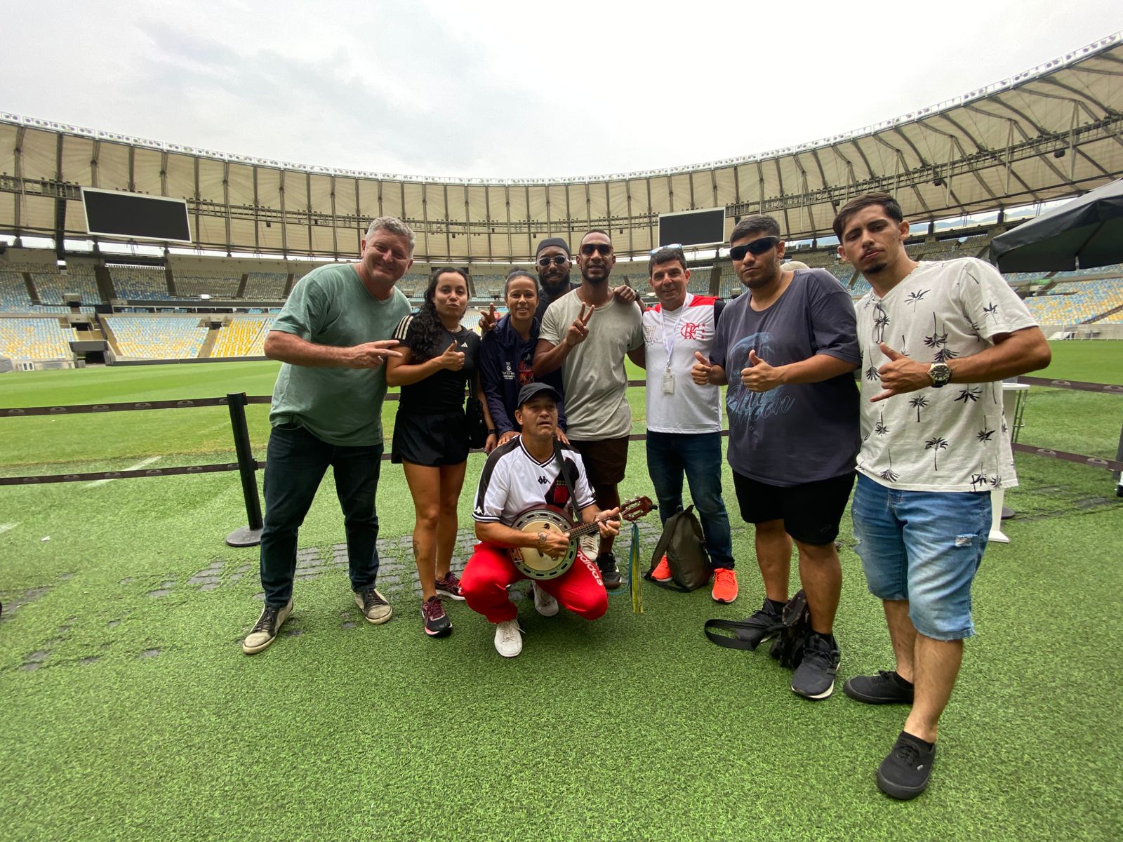 Grupo de turistas com Carlos Ribeiro no gramado do Estádio do Maracanã